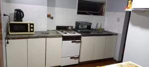 cocina pequeña con fogones y microondas en Departamento Céntrico 2 dormitorios en San Miguel de Tucumán