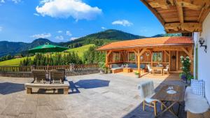 a patio with a gazebo and a table and chairs at Steinberger Hof in Ruhpolding