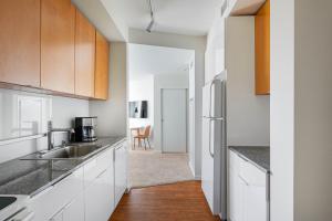 eine Küche mit weißen Schränken und einer Spüle in der Unterkunft Downtown Bellevue Studio w Gym WD nr shops SEA-116 in Bellevue
