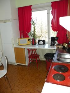 a kitchen with a stove a sink and a window at Guesthouse Kupittaa in Turku