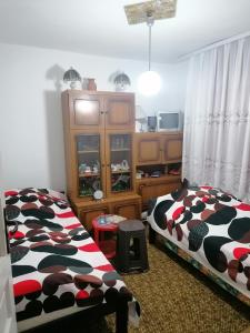 two beds in a bedroom with a cow blanket at STD Verice Đorđević in Kalna