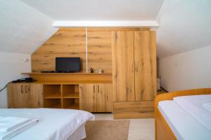 1 dormitorio con 2 camas y armario con TV en Golijski Vuk, en Raška