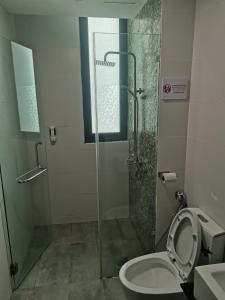 a bathroom with a shower and a toilet with the seat up at teo resident 2 vivacity jazz suite 4 in Kuching