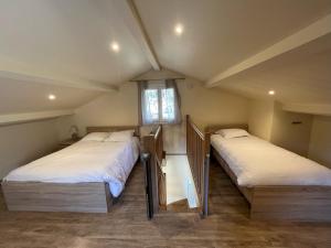 two beds in a small room with a window at Ostan Hôtel Boutique in Roquebillière