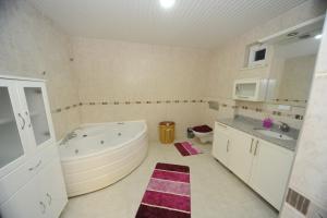 baño grande con bañera grande y 2 lavabos en Prima 9+2 Villas en Alanya