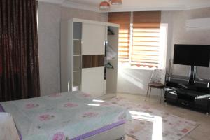 1 dormitorio con 1 cama, vestidor y TV en Prima 9+2 Villas en Alanya