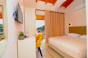 a bedroom with a bed and a tv and a window at Fegi Rooms in Himare
