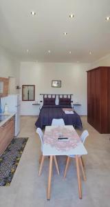 Schlafzimmer mit einem Bett und einem Tisch mit Stühlen in der Unterkunft Il Principe casa vacanze in Trabia