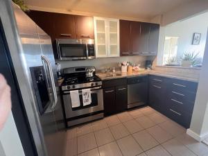 a kitchen with stainless steel appliances and brown cabinets at Amazing Universal Studios Loft FREE parking in Los Angeles
