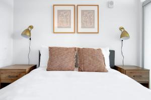 ein Schlafzimmer mit einem weißen Bett mit zwei Lampen in der Unterkunft Bellevue 1BR w BBQ Gym WD nr Spring District SEA-224 in Bellevue + 23 Fotos