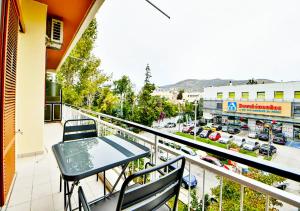 balcón con mesa, sillas y ciudad en Boutique40 Luxury Apartment en Atenas