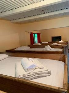a room with three bunk beds with towels on them at Planet B Hostel - Adults Only in Manuel Antonio