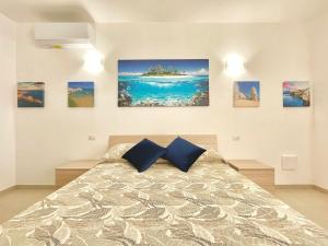 um quarto com uma cama com pinturas na parede em B&B Casa Desimio em Vieste