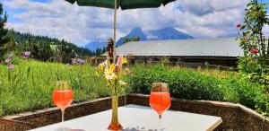 dois copos de vinho sentados numa mesa com um guarda-chuva em 4 Bergpanorama mit herrlicher alpinen Almlandschaft Nichtraucherdomizil em Schönau am Königssee