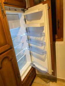 an empty refrigerator with its door open in a kitchen at Chalet, Bagnes, Suisse in Le Châble