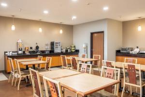 a dining room with wooden tables and chairs at Quality Suites NE Indianapolis Fishers in Fishers