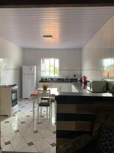 Il dispose d'une grande cuisine avec une table et un réfrigérateur. dans l'établissement Casa Aconchego Mineiro, à Ouro Preto