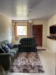 un salon avec un canapé et une chaise dans l'établissement Casa Aconchego Mineiro, à Ouro Preto