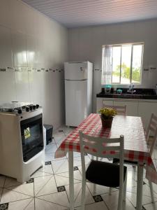 une cuisine avec une table, une cuisinière et un réfrigérateur dans l'établissement Casa Aconchego Mineiro, à Ouro Preto