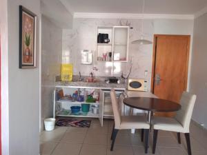 a small kitchen with a table and chairs in a room at APARTAMENTO AGUAS DA SERRA 713 A in Rio Quente