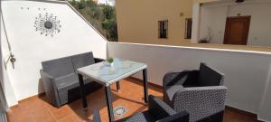 d'un balcon avec des chaises, une table et un miroir. dans l'établissement ALIRE YUCAS, à Fuengirola