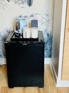 a black refrigerator with two mugs on top of it at Manoir de Beaupré in Vannes