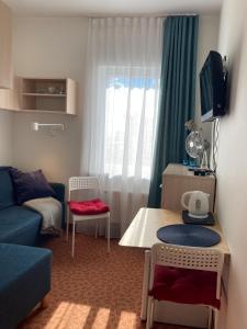 ein kleines Wohnzimmer mit einem blauen Sofa und einem Tisch in der Unterkunft Villa Baltic Chałupy - Apartament nr 14A in Chałupy