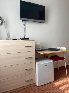 a bedroom with a dresser and a desk with a tv at Villa Baltic Chałupy - Apartament nr 14A in Chałupy