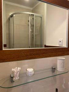 a bathroom with a large mirror and a glass sink at Villa Baltic Chałupy - Apartament nr 14A in Chałupy