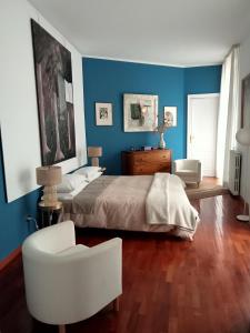 ナポリにあるAltera Domusの青い壁のベッドルーム1室、ベッド1台、椅子1脚が備わります。