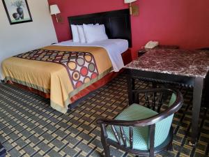 Habitación de hotel con cama, escritorio y silla en Budget Inn en Texarkana