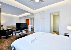 a bedroom with a large white bed and a living room at Boutique40 Luxury Apartment in Athens