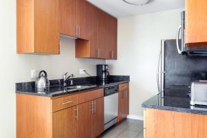 a kitchen with wooden cabinets and black counter tops at Cupertino 1BR w Pool Gym AC nr shops SFO-371 in Cupertino