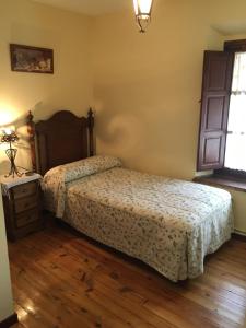 a bedroom with a bed and a dresser and a window at Casa Antigua con encanto en Cabañeros in Retuerta de Bullaque