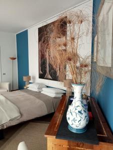 ナポリにあるAltera Domusのベッドルーム1室(ベッド1台、テーブル上の花瓶付)