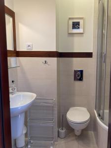 a bathroom with a toilet and a sink at Villa Baltic Chałupy - Apartament nr 14A in Chałupy