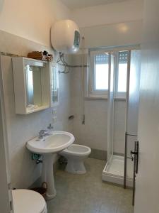 a bathroom with a sink and a toilet and a shower at Appartamento Indipendente al Mare Sweet Apartments in Santa Marinella