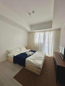 ein Schlafzimmer mit einem großen Bett und einem Fenster in der Unterkunft The Patio at Monaco Tower in Lagundi