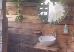 Chinauta_Eco_Glamping في فوساغاسوغا: حمام مع حوض على جدار خشبي
