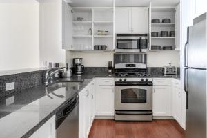 eine Küche mit weißen Schränken und Geräten aus Edelstahl in der Unterkunft Santa Clara 1BR w Parking Gym nr Groceries SFO-437 in Santa Clara