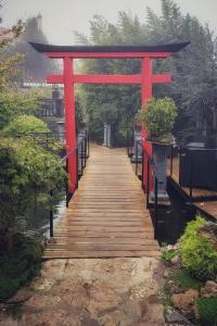 a red torii gate over a wooden walkway at Zen Museu do Bonsai in Sintra