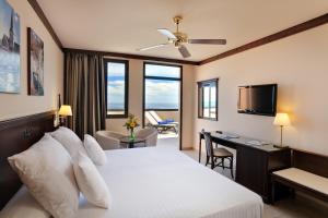 a bedroom with a bed and a desk and a television at Occidental Jandía Royal Level - Adults Only in Morro del Jable +57 photos