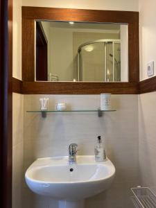 W łazience znajduje się biała umywalka i lustro. w obiekcie Villa Baltic Chałupy - Apartament nr 14A w Chałupach