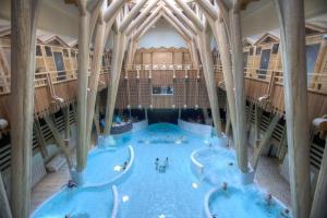 una gran piscina cubierta con gente. en Carré Py' Hôtel, en Bagnères-de-Bigorre