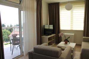a living room with a couch and a tv and a balcony at Apartments Lavanda in Budva