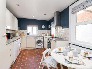 a kitchen with a white table and chairs in it at Quay Cottage in Weymouth +13 photos
