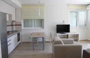 a kitchen and living room with a table and chairs at Apartments Lavanda in Budva