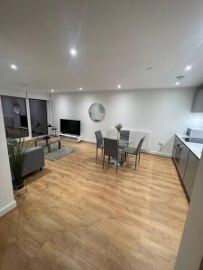 a living room with a table and chairs and a kitchen at Stunning 2 bed/2 bath Apartment in Warlingham