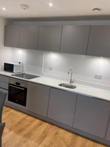 a kitchen with a sink and a microwave at Stunning 2 bed/2 bath Apartment in Warlingham