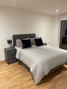 sypialnia z dużym łóżkiem i stolikiem nocnym w obiekcie Stunning 2 bed/2 bath Apartment w mieście Warlingham